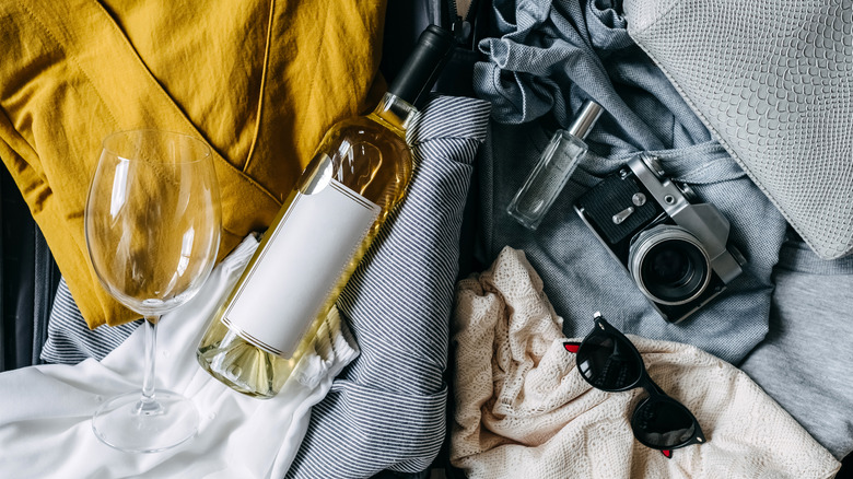 suitcase with clothes and wine