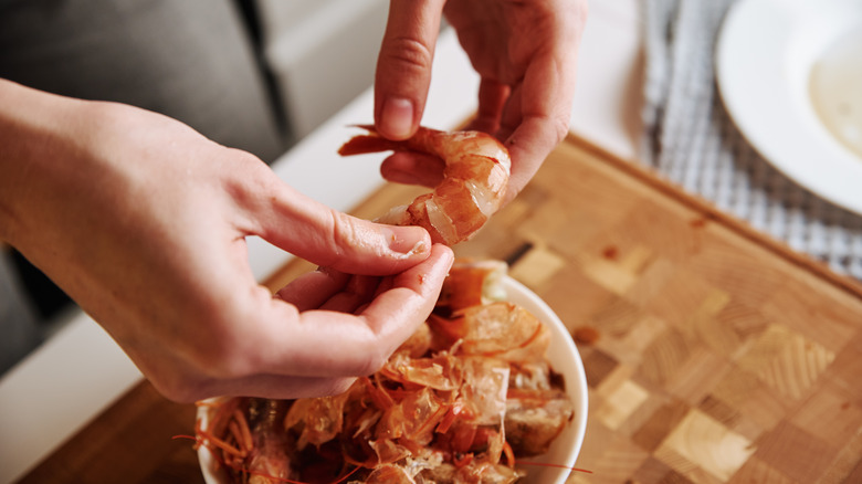 Peeling pink cooked shrimp