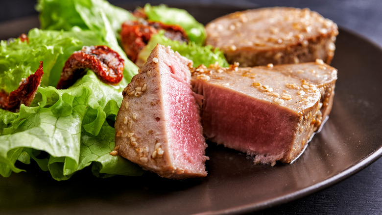 Sliced tuna steak with side salad