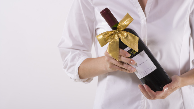 woman holding gift wine bottle