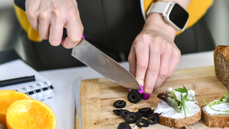 woman slicing olives knife