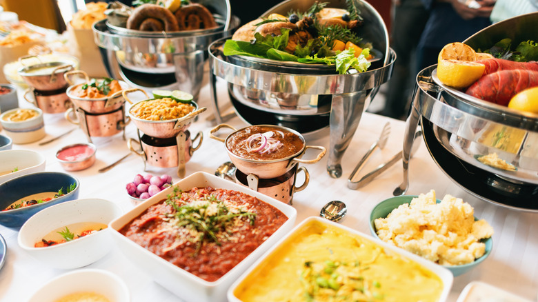 Buffet table with tall dishes in back, shorter trays in front