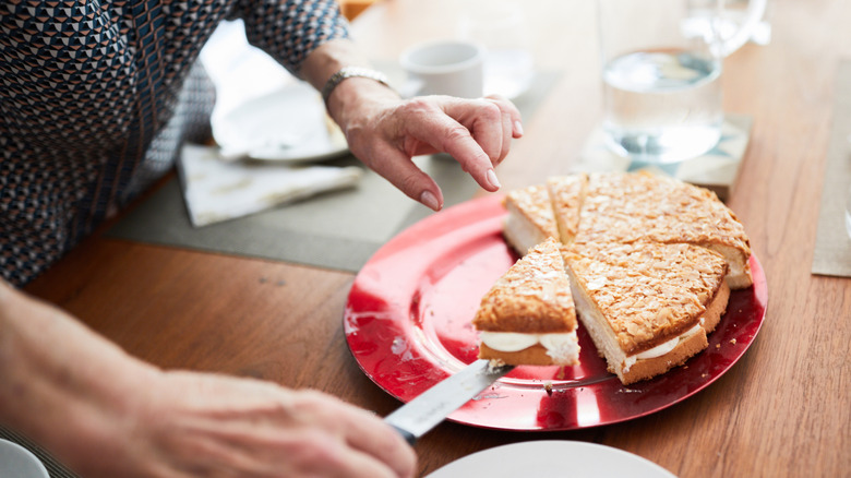 Woman taking a piece of sliced cake