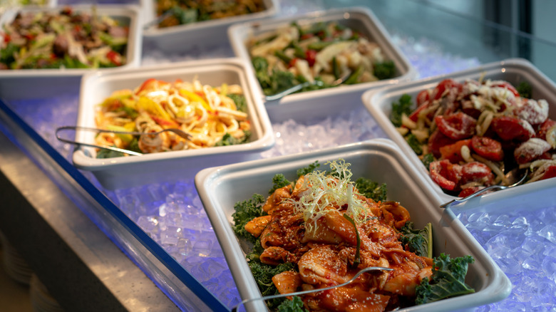 Buffet showing a variety of cold dishes placed over a long tray of ice