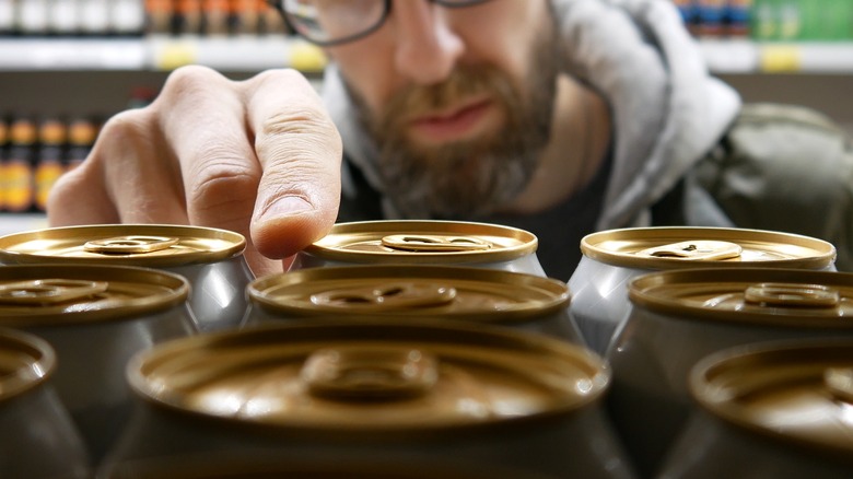 man choosing a can of beer