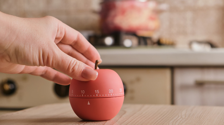 Close-up of person's hand adjusting kitchen timer