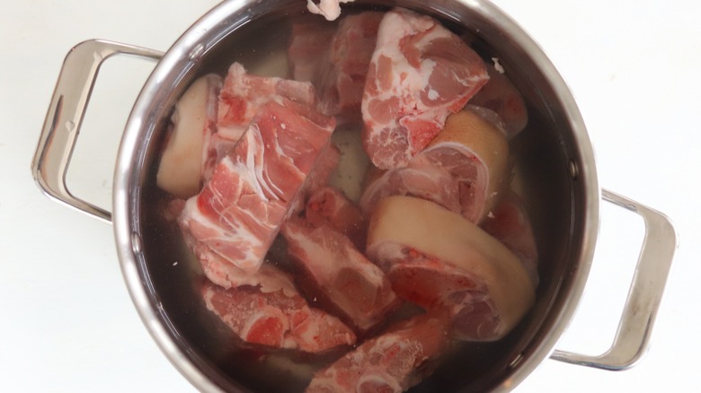 Top-down view of soaking pork bones in a pot