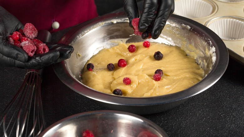 Adding berries to batter in bowl