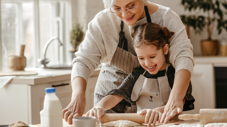 A woman and a young girl rolling out dough at home