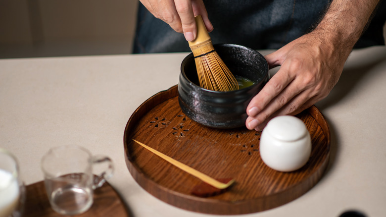 Person whisking matcha powder