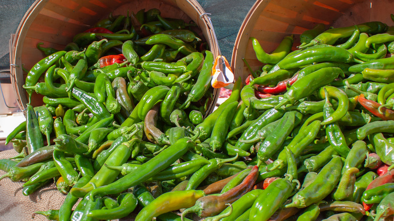 two baskets with green chiles overflowing