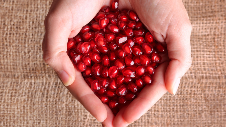 Pomegranate seeds in someone's hand