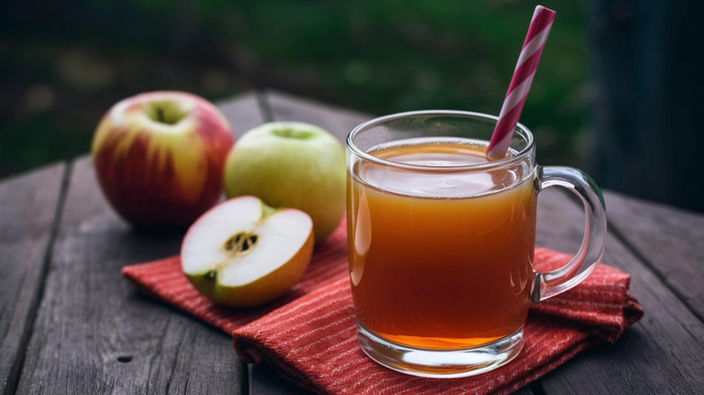 apple cider in a glass with whole apples