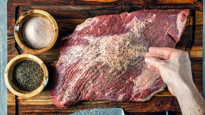 seasoning brisket with salt and pepper