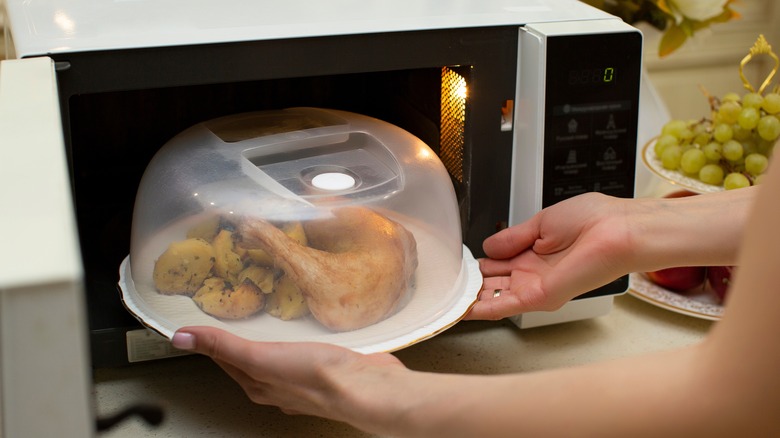 Person putting food in microwave