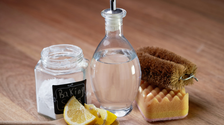 Bottle of vinegar with cleaning supplies