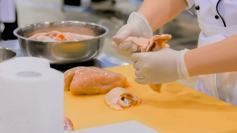 chef removing chicken from bone