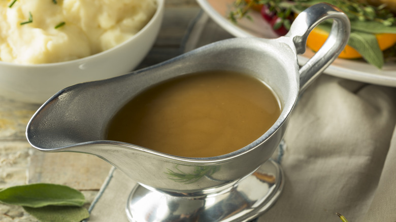 A serving of turkey gravy surrounded by side dishes