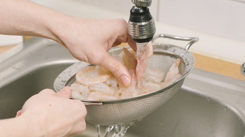 Rinsing shrimp under faucet