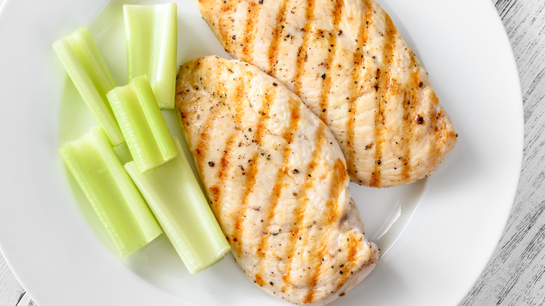 plain grilled chicken breasts with celery on white plate