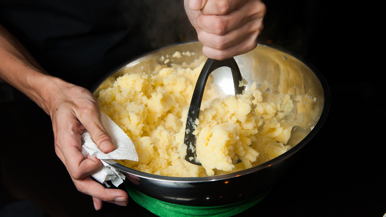 mashing potatoes in bowl