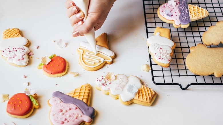 Squeezing icing bag to decorate cookies