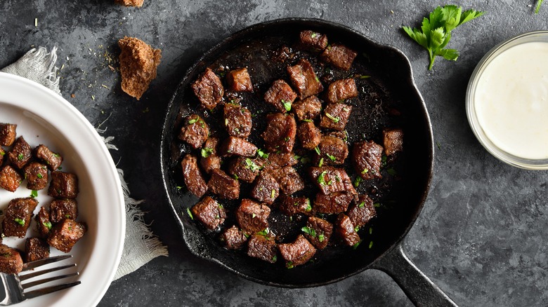 Meat cooking in cast iron pan