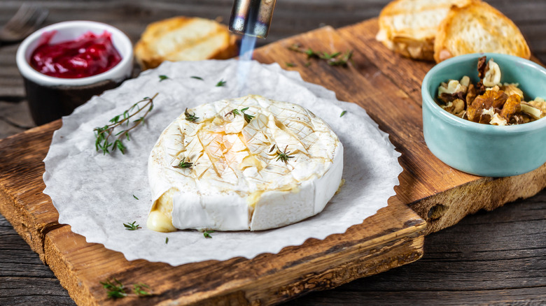 Brie on wooden board with accoutrements