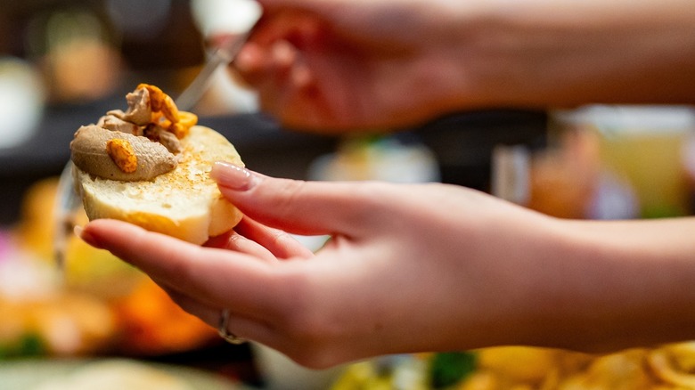 Hands spreading foie gras on bread