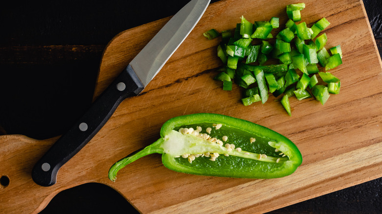 Jalapeños and knife on cutting board 