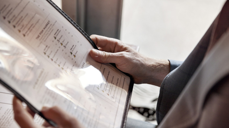 Close-up of hands holding a menu