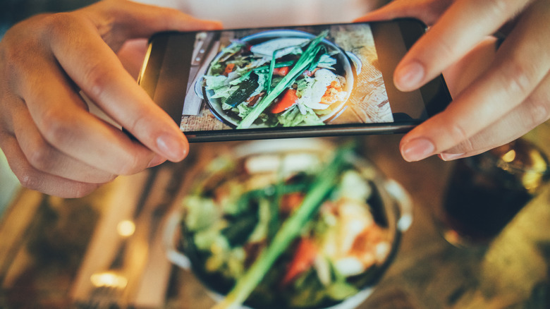 Person taking photo of food with phone
