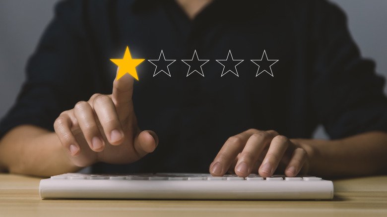 Person with keyboard selecting one star out of five