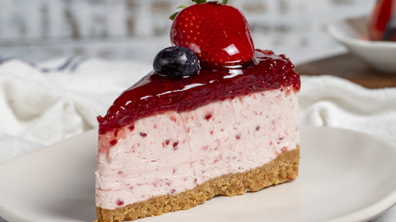 strawberry cheesecake slice with berry glaze and blueberry topping