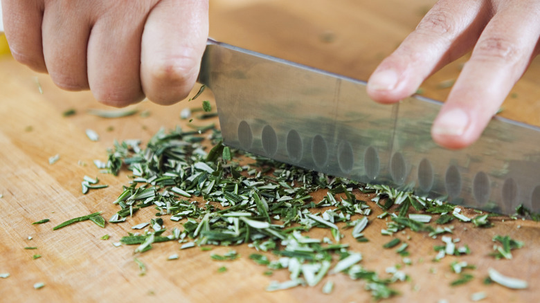 Knife chopping rosemary