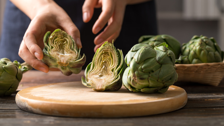 preparing artichokes on wooden board