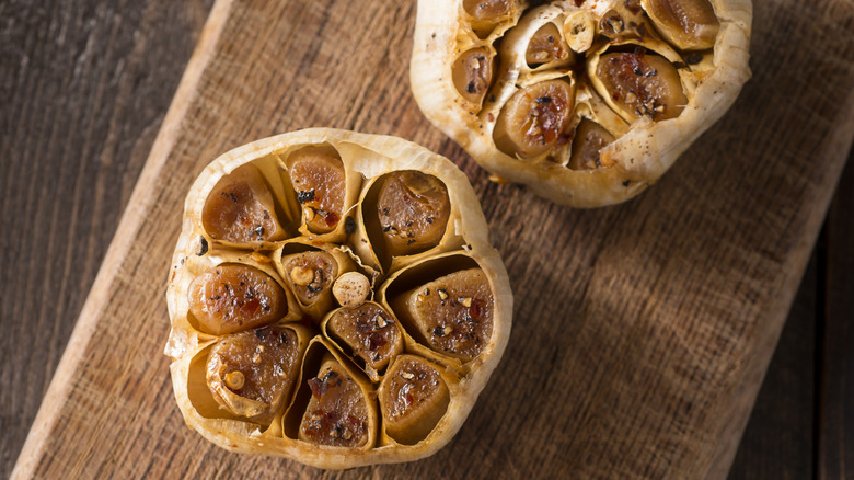 two Roasted garlic cloveson cutting board