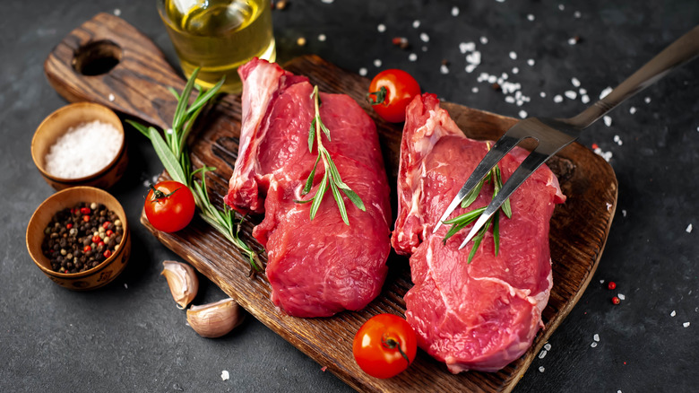 Raw steaks on cutting board