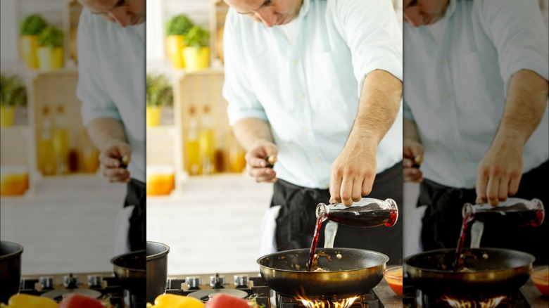 Pouring red wine into pan stovetop