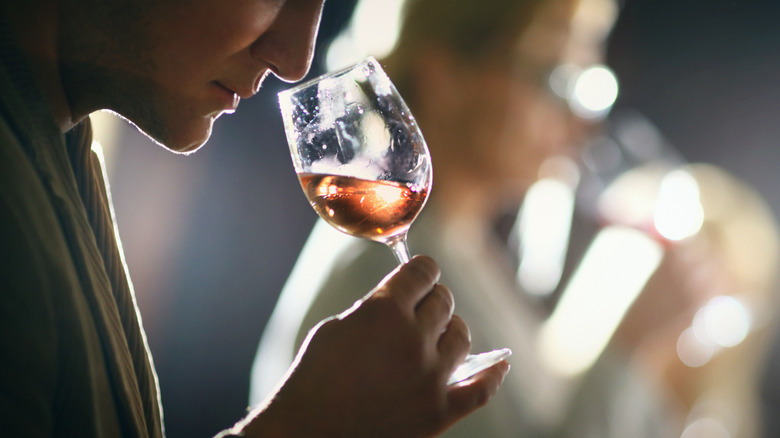 person smelling wine in glass