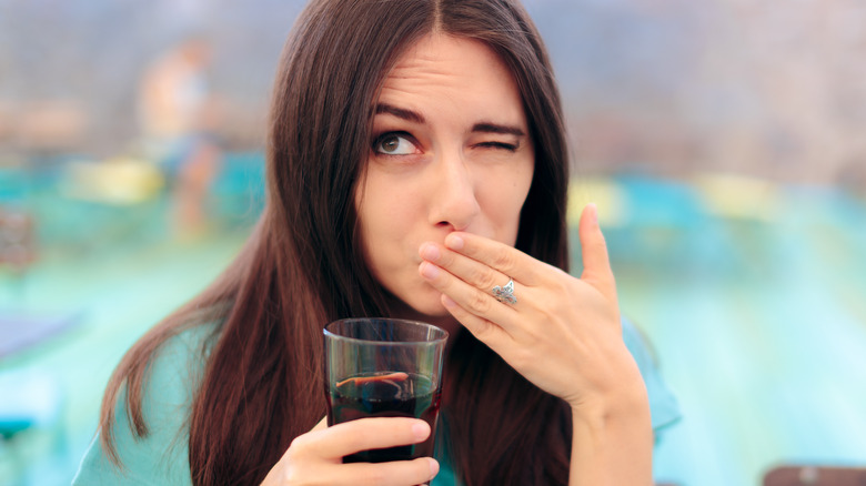 Person making odd face from wine