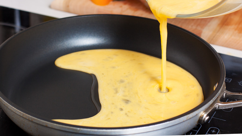 pouring eggs into pan