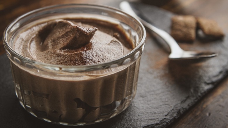 chocolate mousse in small glass bowl next to spoon