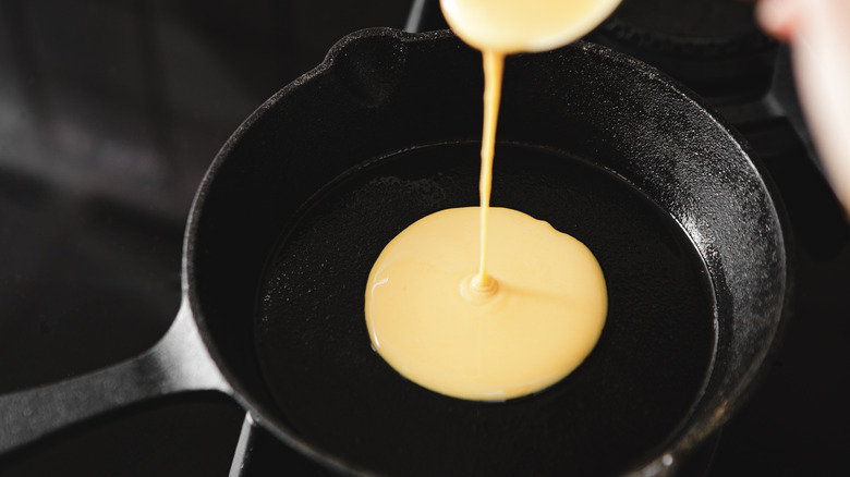 Pouring pancake batter into skillet