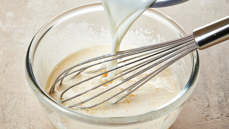 Whisking cream into egg mixture for custard