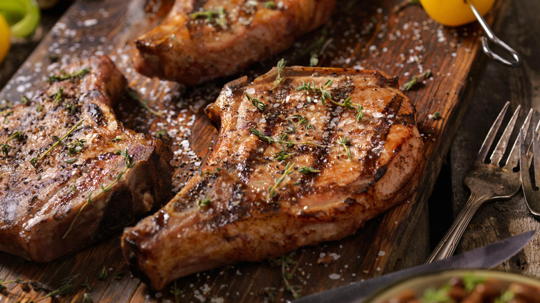 Pork chops on wooden serving board