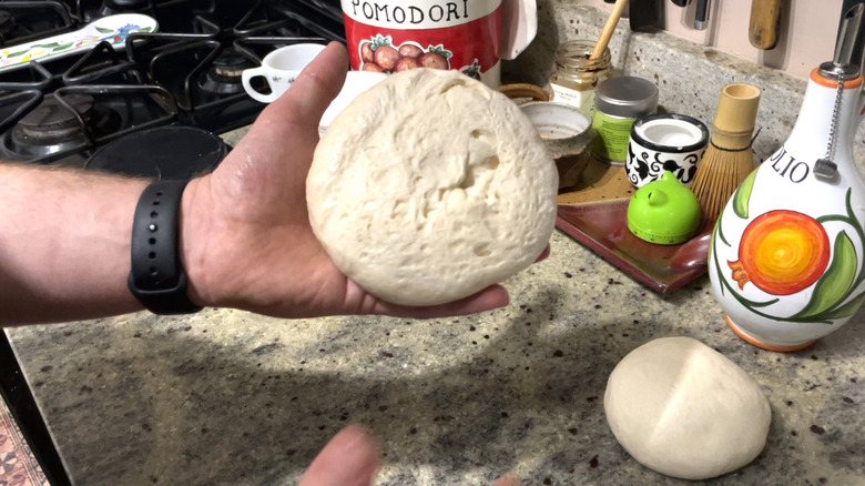 Hand showing underside of dough