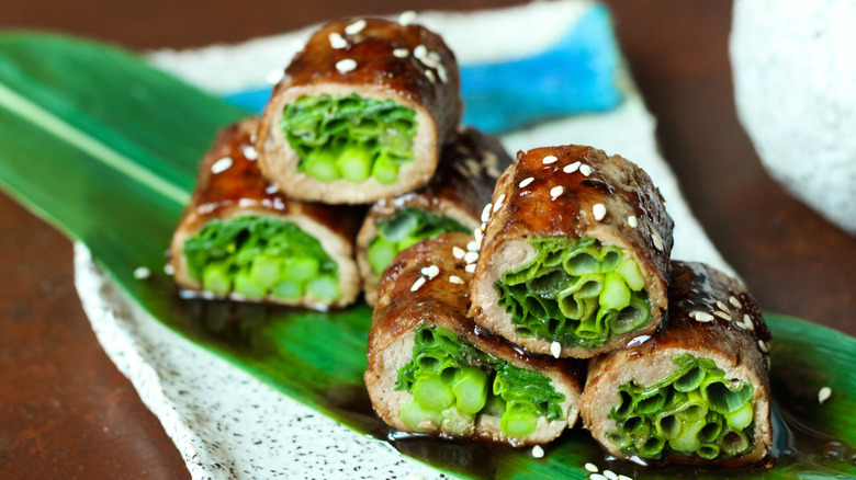 beef negimaki sushi rolls plated on banana leaf