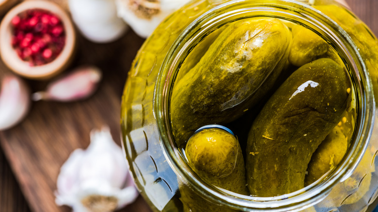 Open jar of pickles with other ingredients 