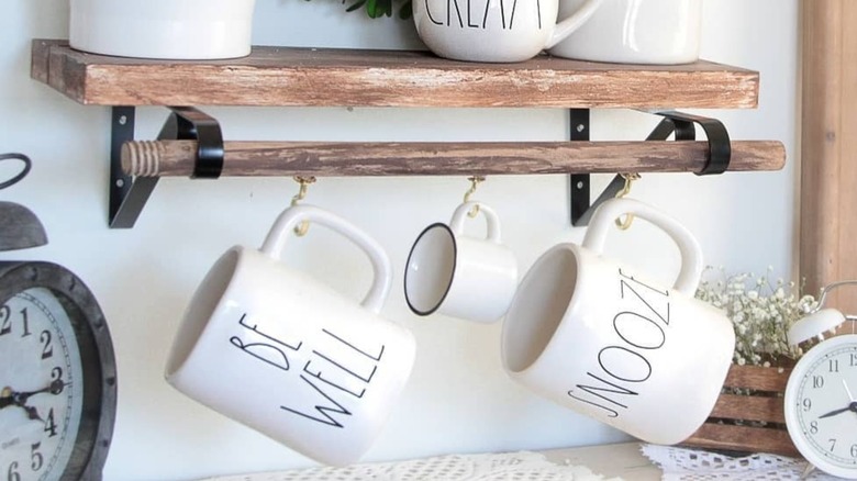 A coffee mug rack made from a wooden toilet plunger handle